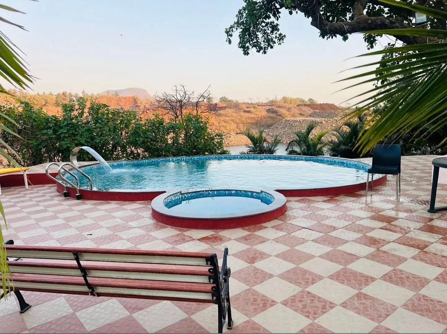 A circular swimming pool with a stainless-steel water blade, built by PBJ Infra at Aandra Lakestay Resort, Pune