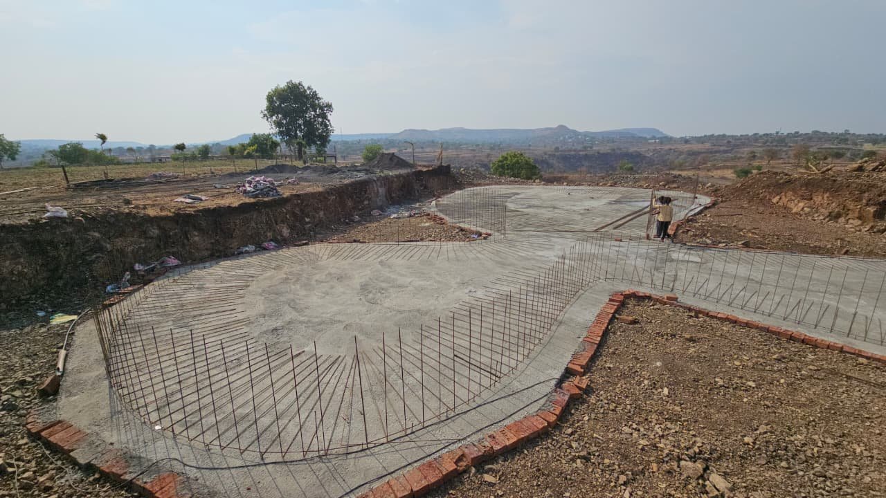 Starter bars fanned out around the curved edge of the pool's base slab at Brahma Valley, ready for the wall reinforcement