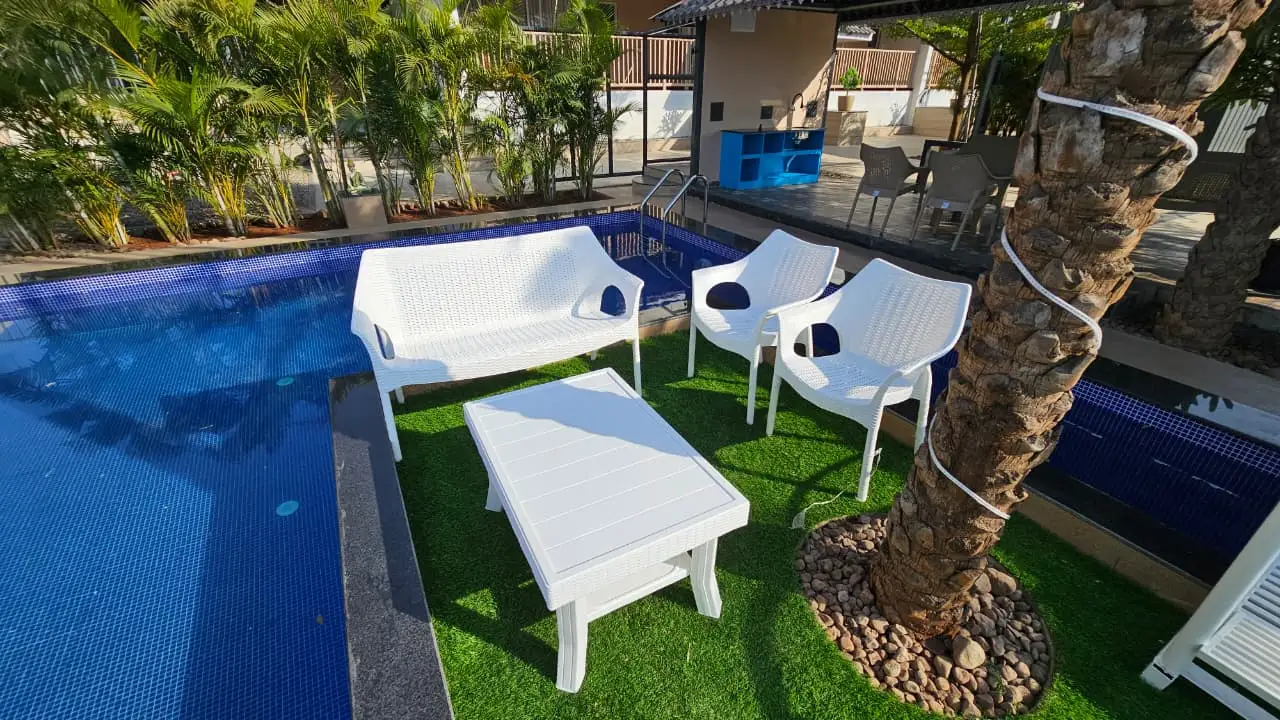 Poolside lounge seating beside a blue mosaic-tiled swimming pool at AK Gemak Resort, Kolhapur, built by PBJ Infra