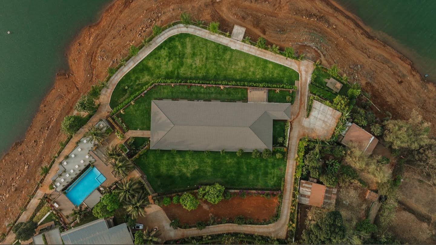 Overhead drone view of the resort layout, with water on two sides of the landscaped site