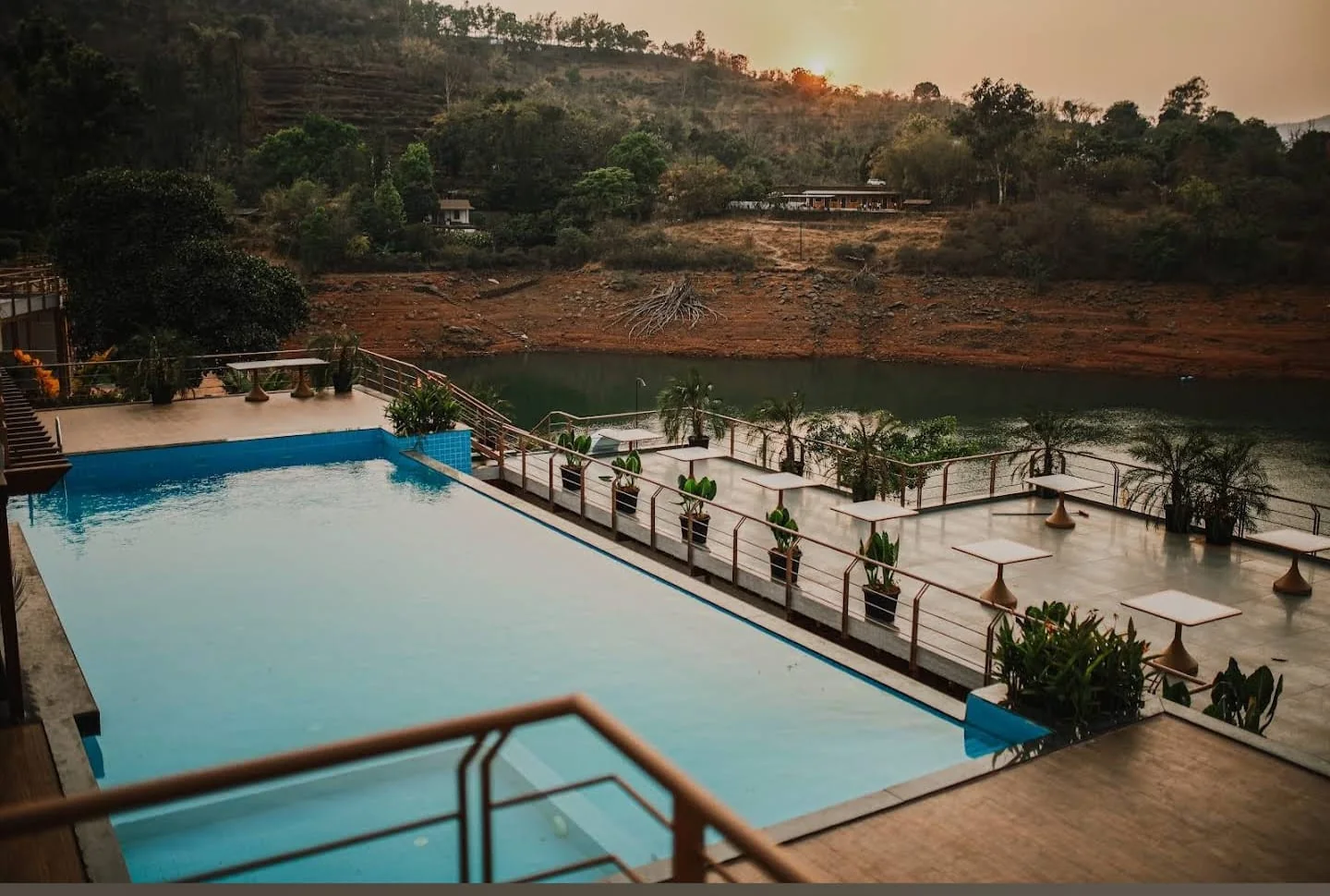 Infinity-edge pool and sun deck overlooking the Panshet backwaters at sunset, built by PBJ Infra