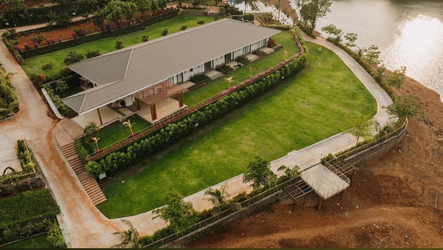 Main hall and timber pergola opening onto the event lawn, the reservoir beyond