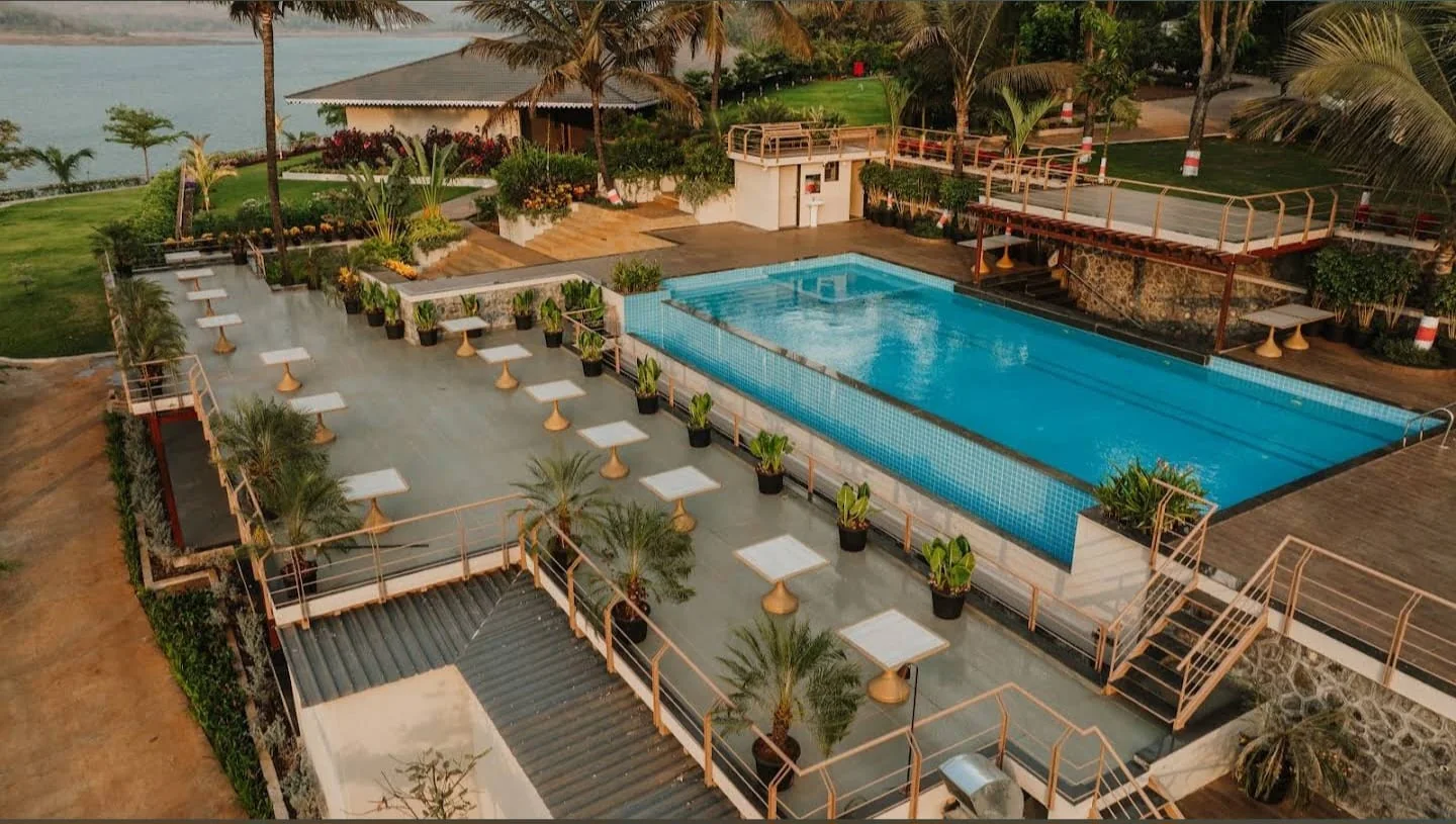 The main pool and its stepped sun deck with cabana tables, overlooking the lakeside pavilion