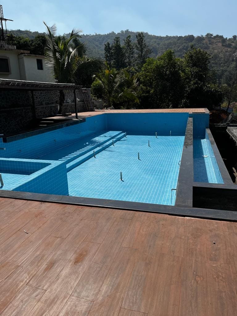 The resort pool during construction — shell, steps and blue mosaic tiling, before the deck was laid