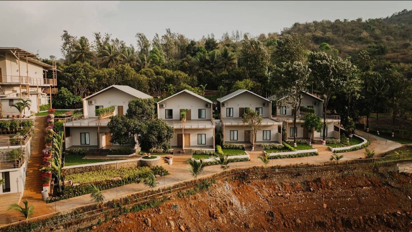 A row of gable-roofed villa cottages stepped along the hillside above the water